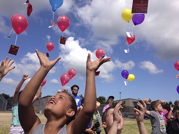 Children release balloons attached to copies of Carew Papritz’s latest book