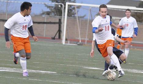 Auburn Mountainview's Tyler Persons battles a Lakes defender for possession of the ball as teammate Issac Cardoza anticipates a possible pass.