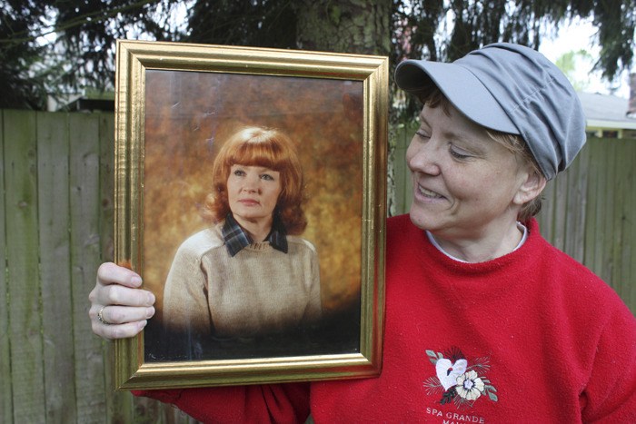 Dawn Revell holds a portrait of her mother Brenda Revell Moss.
