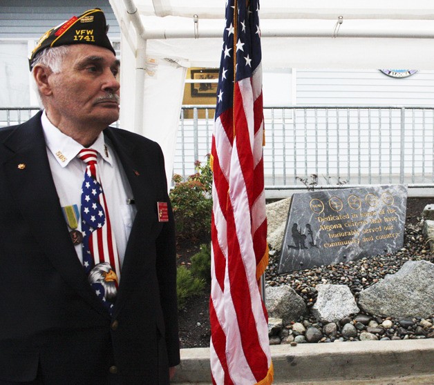 Auburn VFW Post 1741 honor guard Ernest Landini looks on in front of the Algona Veterans Memorial