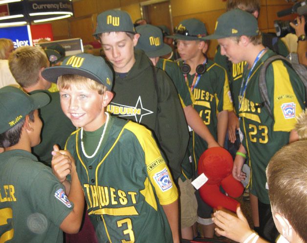 Robbie Wilson (3) and his teammates receive congratulations from family and friends after landing at Sea-Tac Airport on Monday night. The team had been on the road for most of the month competing at the state