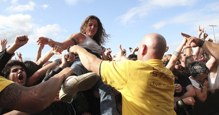A crowd surfer is helped to safety by security during Trivium's set at the 2011 Mayhem Festival.