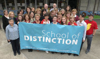 Teachers and staff of Pioneer Elementary School proudly display their well-earned ‘school of distinction’ banner.