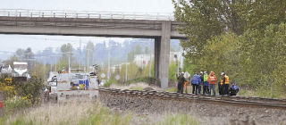 Officials investigate the scene after an Amtrak passenger train struck and killed a 50-year-old Auburn man Wednesday.
