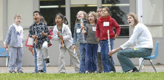Kindergarten students from Pioneer Elementary School watch one of their rockets soar through the air after launch with the help of parent volunteer Amy Baxley. Students in Ruby Chock’s a.m. and p.m. classes built and launched the stomp rockets with the Tacoma Astronomical Society. More photos