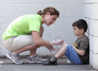 Summer Day Camp supervisor Lindsay Richards gives Justin Heindel