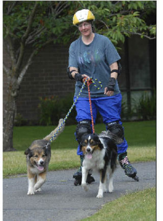 Lisa Majestic scoots through Les Gove Park on roller blades with help from her two dogs