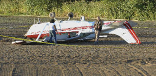 A small plane flipped over after landing in a plowed field along Green Valley Road on Monday.