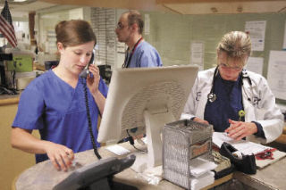 Nurses and doctors work at the nurses’ station in the ER at Valley Medical Center.