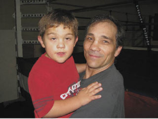 Former world champion boxer Greg Haugen holds his autistic grandson