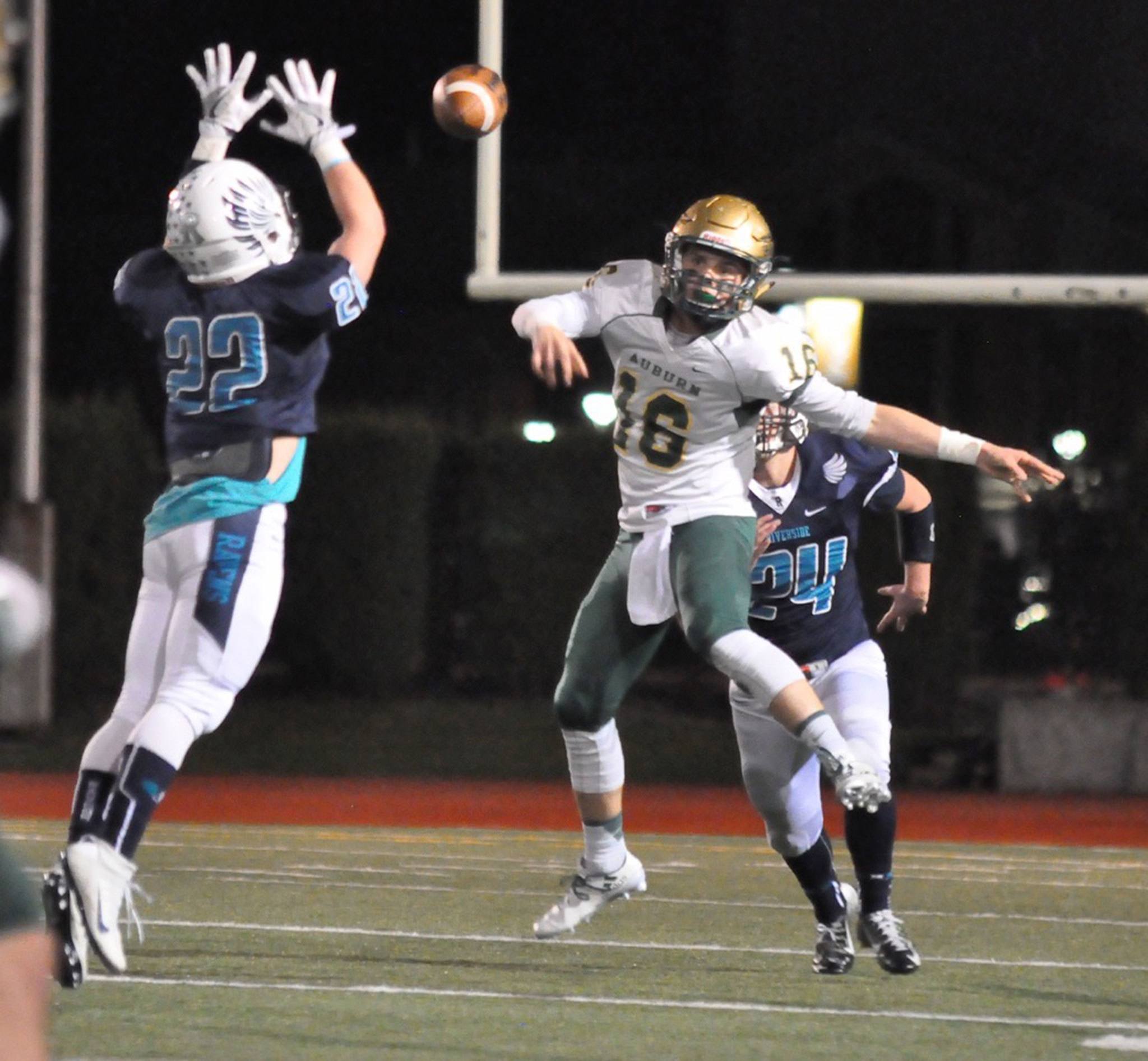 Auburn Riverside’s Alex Caldwell attempts to block a throw from Auburn quarterback Zach Redelf during NPSL play Friday night. RACHEL CIAMPI, Auburn Reporter