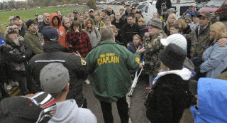 A chaplain from the King County Sheriffs Department tells a group of family and friends about the status of the recovery effort in the Green River.