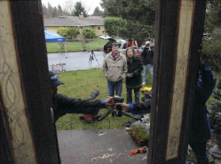 Scott and Cat Eidness look on as crews install the new front door to their West Hill home on Tuesday.