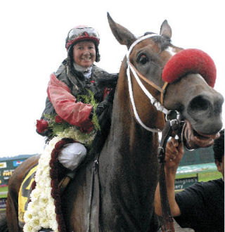 Veteran jockey Jennifer Whitaker is all smiles in the winners’ circle after guiding Wasserman to victory in the 73rd Longacres Mile at Emerald Downs on Sunday.