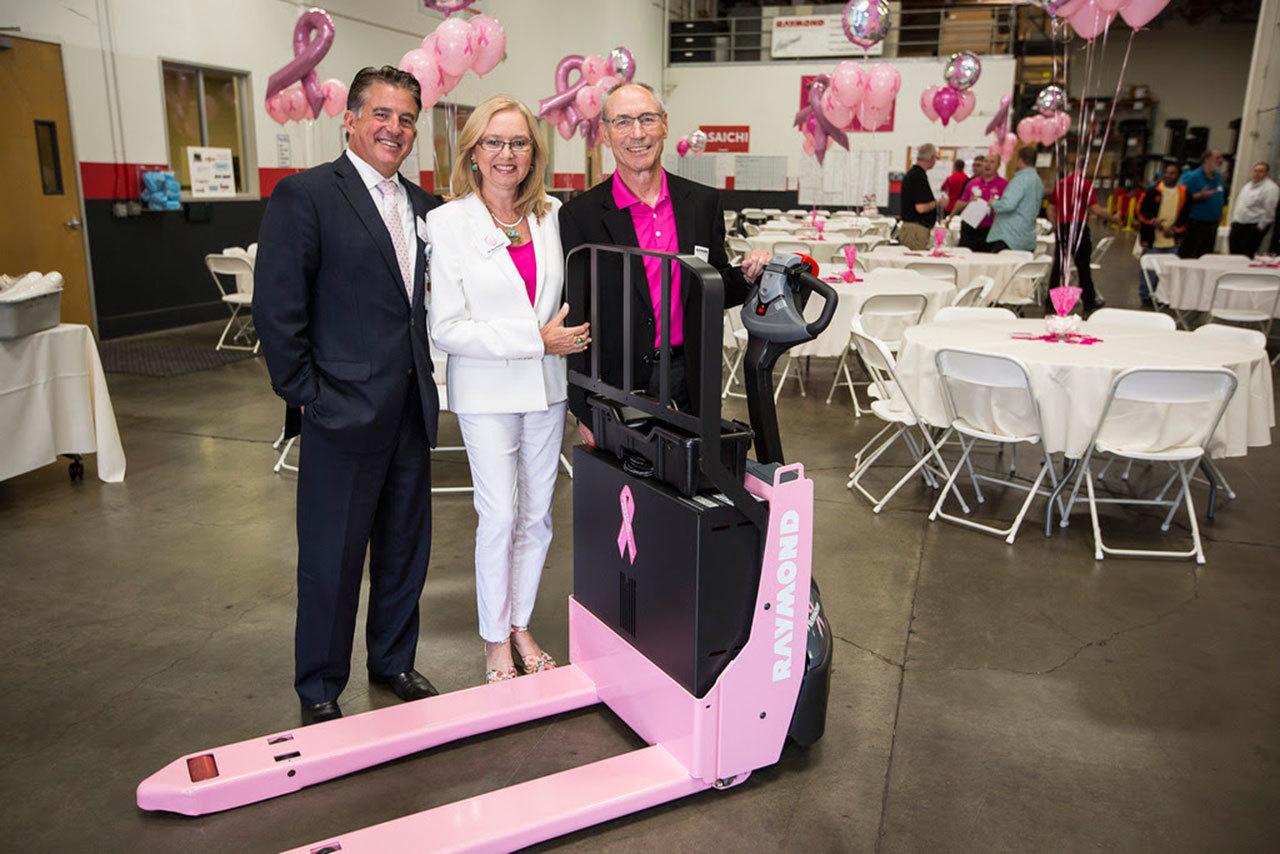 Michael Engle, left, board chair of HERS Breast Cancer Foundation, Vera Packard, middle, executive director of the foundation, and Steve Raymond, president of Raymond Handling Concepts Corp., display the Pink Pallet Jack Pro at an open house event in Fremont, Calif. COURTESY PHOTO