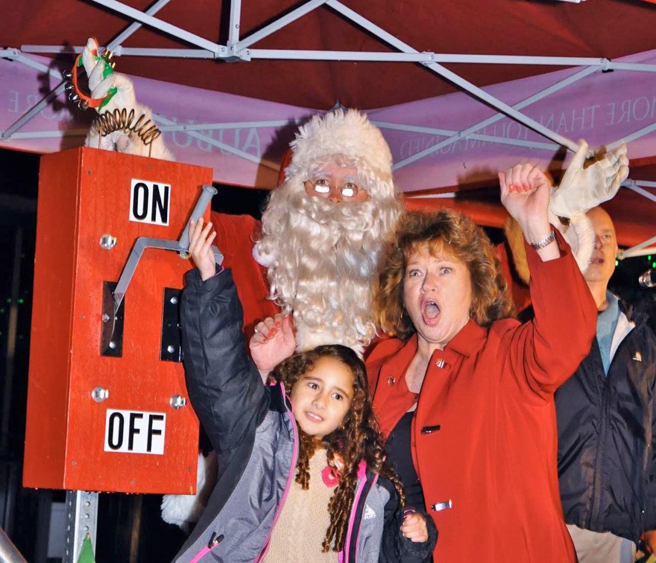 Mayor Nancy Backus, Stefany Sanchez and Santa help turn the switch on to light up the Christmas tree in the City Hall Plaza last year. RACHEL CIAMPI, Auburn Reporter