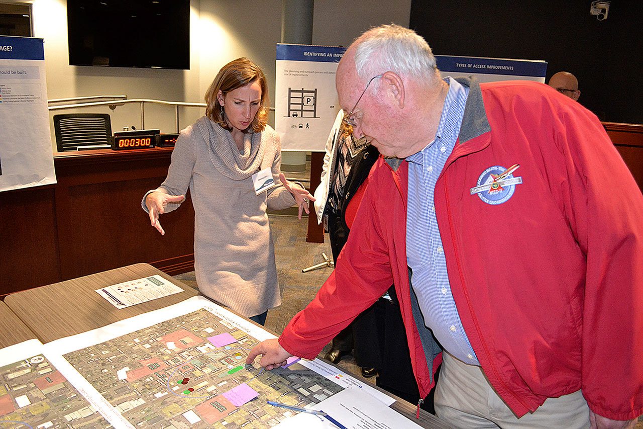 Chelsea Levy, government and community relations manager for Sound Transit, left, and former Auburn City Councilman Wayne Osborne examine a map displaying a range of possible sites for the agency’s second transit parking garage in Auburn, during a recent community forum on the project at Auburn City Hall. REPORTER PHOTO, Robert Whale