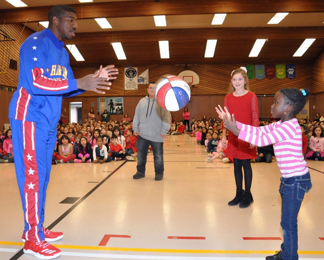 Anthony ‘Buckets’ Blakes throws the ball to Fatoumata Sanneh during the Harlem Globetrotter’s visit to Evergreen Heights Elementary School on Tuesday. RACHEL CIAMPI, Auburn Reporter