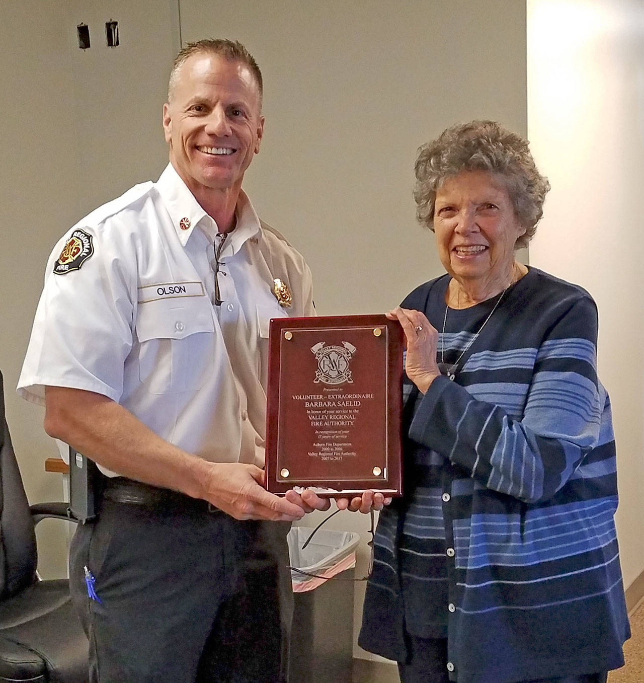 Kevin Olson, the Valley Regional Fire Authority deputy fire chief of technical services, presents volunteer Barbara Saelid with a plaque in honor of her 17 years of dedicated service to the legacy Auburn Fire Department and the VRFA. COURTESY PHOTO, VRFA