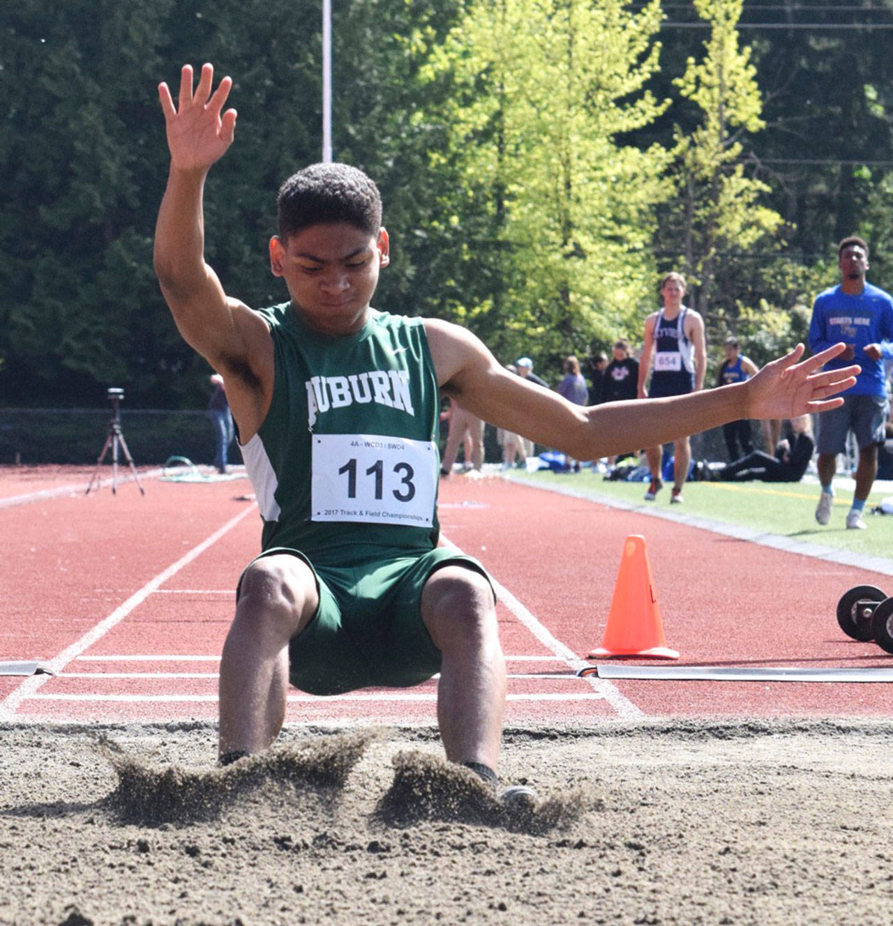 Auburn’s D’Angelo Washington lands in the sand after taking the district long jump title with a leap of 22 feet, 7 inches on Thursday at French Field. RACHEL CIAMPI, Auburn Reporter