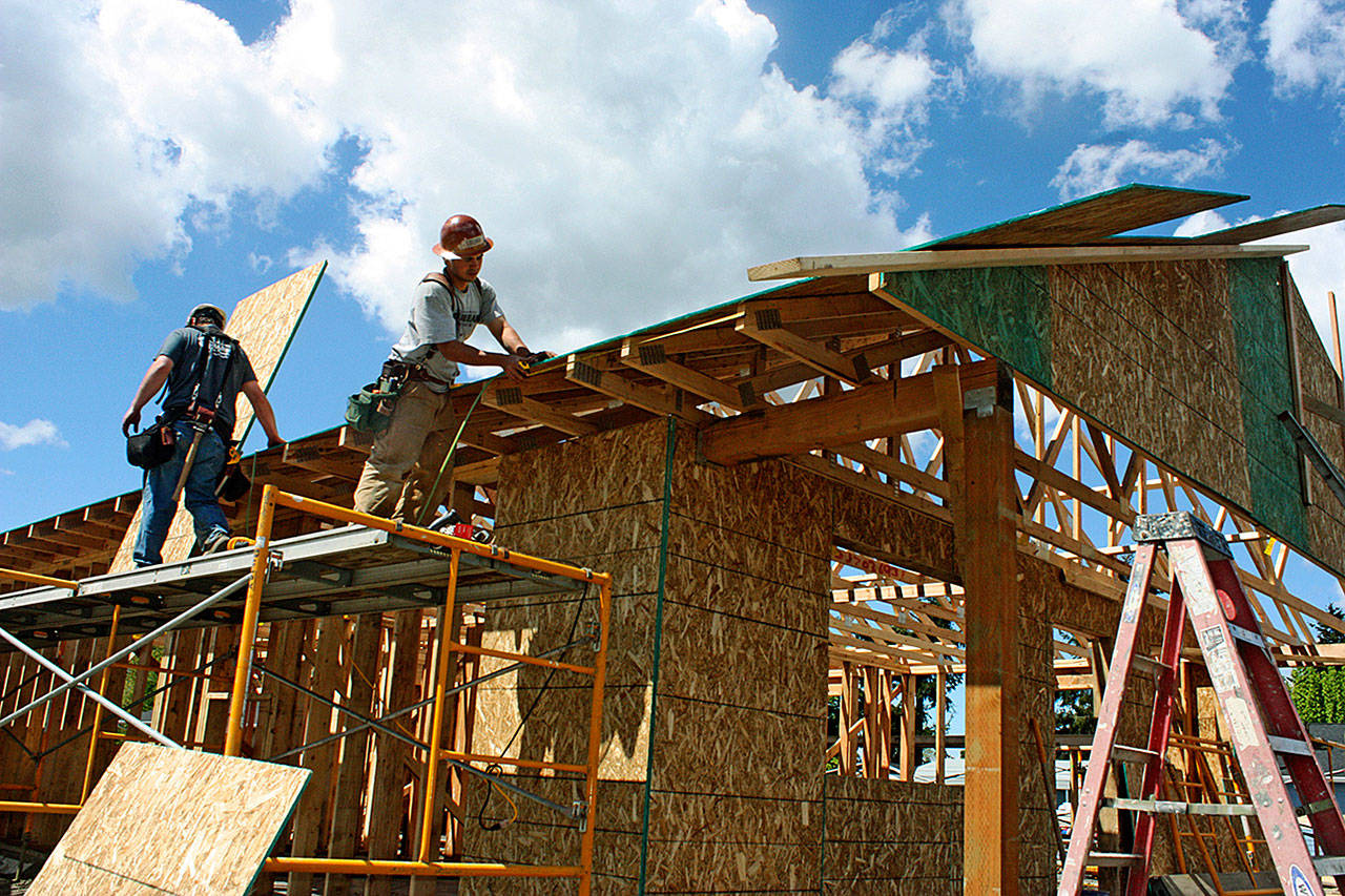 Volunteers continue to work on the nine-unit, veterans-focused community in Pacific last Saturday. Habitat for Humanity Seattle-King County and its partners are leading the effort. MARK KLAAS, Auburn Reporter