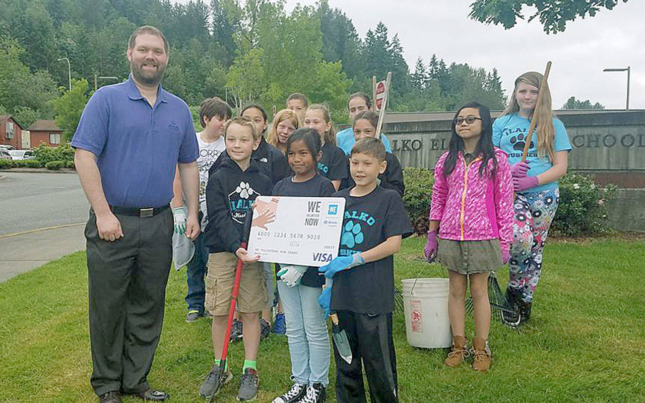 Allstate representative Michael McKee presents Ilalko Elementary students with a $250 WE Volunteer Now grant to put toward their beautification project at the school Tuesday. COURTESY PHOTO