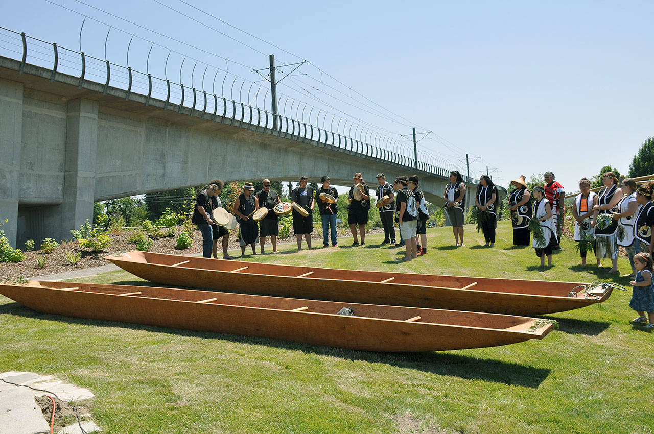 Muckleshoot Tribal members bless two canoes during a ceremony at Tukwila’s Duwamish Gardens last week. HEIDI SANDERS, Kent Reporter
