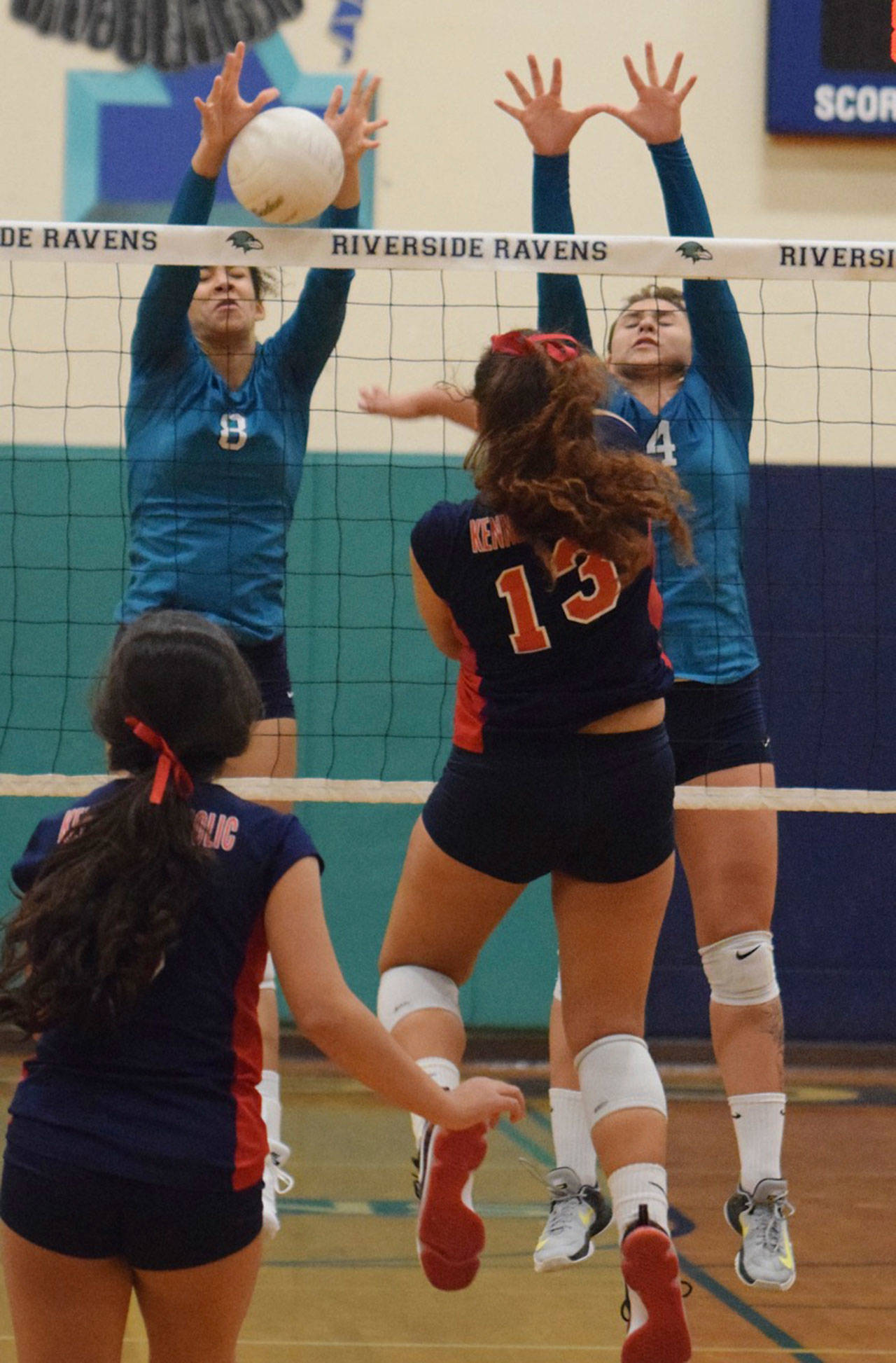 Auburn Riverside’s Brianna Ingram, left, and Kate Pestova apply a wall to stop Kennedy Catholic hitter Haley Moore during NPSL volleyball play Wednesday night. RACHEL CIAMPI, Auburn Reporter