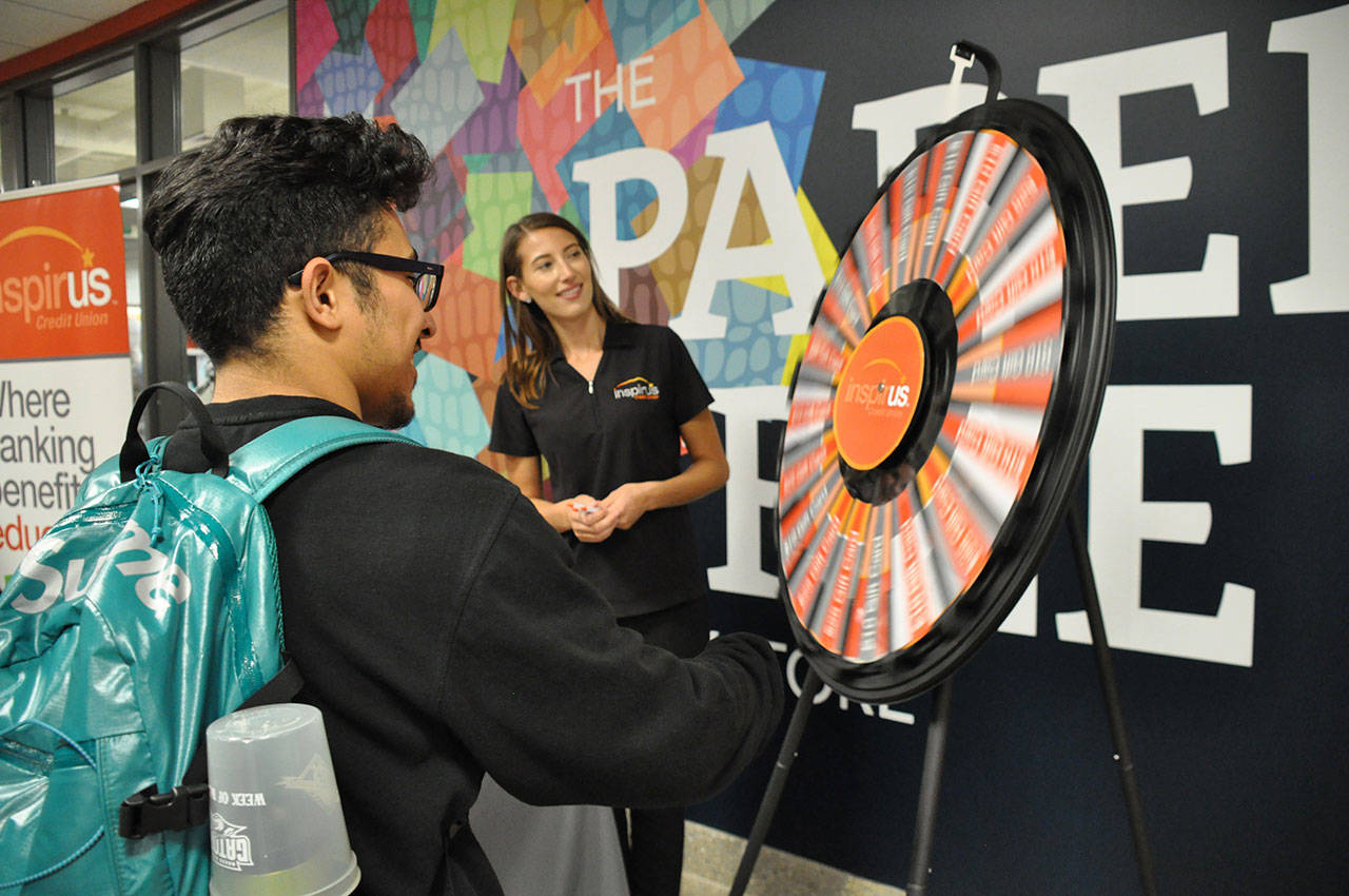 Aaron Orozco, of Renton, spins the wheel to win a gift card to the Green River College bookstore. Inspirus Credit Union handed out $10, $25 and $50 gift cards to students on the college’s main campus in Auburn for the first day of the fall quarter on Monday. HEIDI SANDERS, Kent Reporter