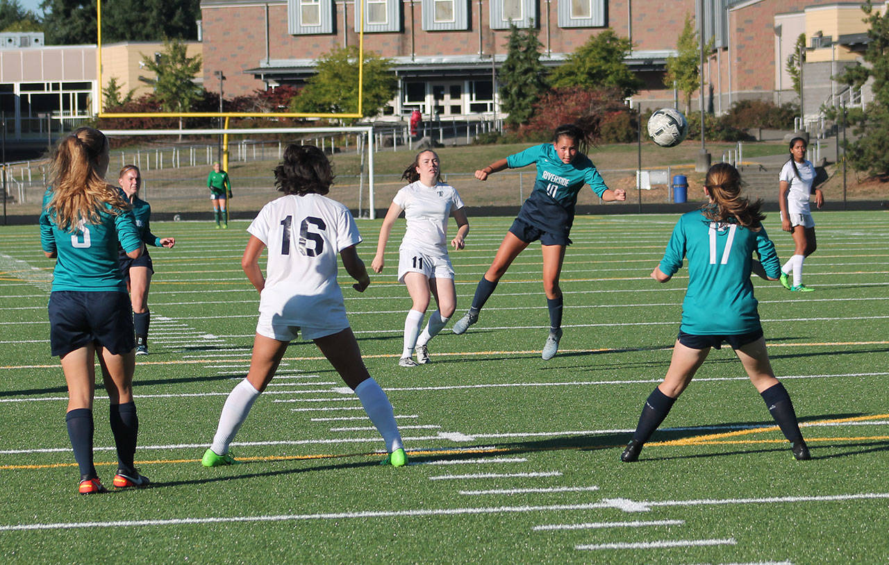 Auburn Riverside’s Kailee James heads the ball forward to teammate Sierra Parshall during NPSL Olympic Division soccer play on the Todd Beamer pitch on Tuesday. JAROD YOUNG, Federal Way Mirror