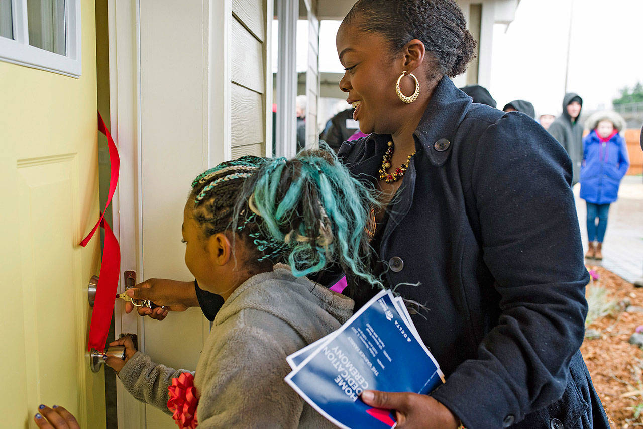 Maclovia Varner, a U.S. Army veteran and administrative officer in the aviation industry, and her daughter open the door to their new home at Megan’s Meadow in Pacific during a dedication ceremony on Nov. 3. COURTESY PHOTO