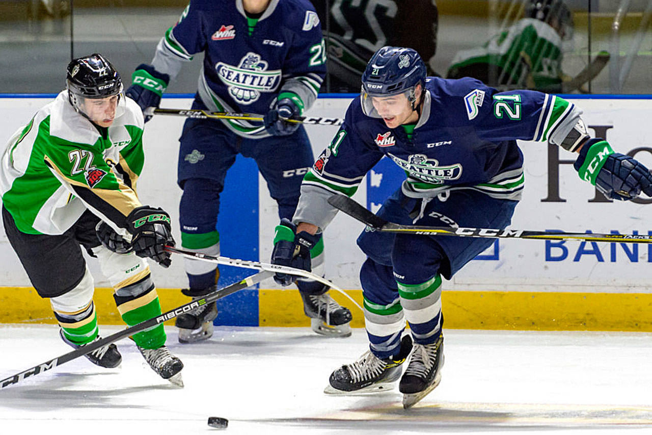 The Thunderbirds’ Matthew Wedman, right, and the Raiders’ Carson Miller vie for the puck during WHL play Tuesday night. COURTESY PHOTO, Brian Liesse, T-Birds