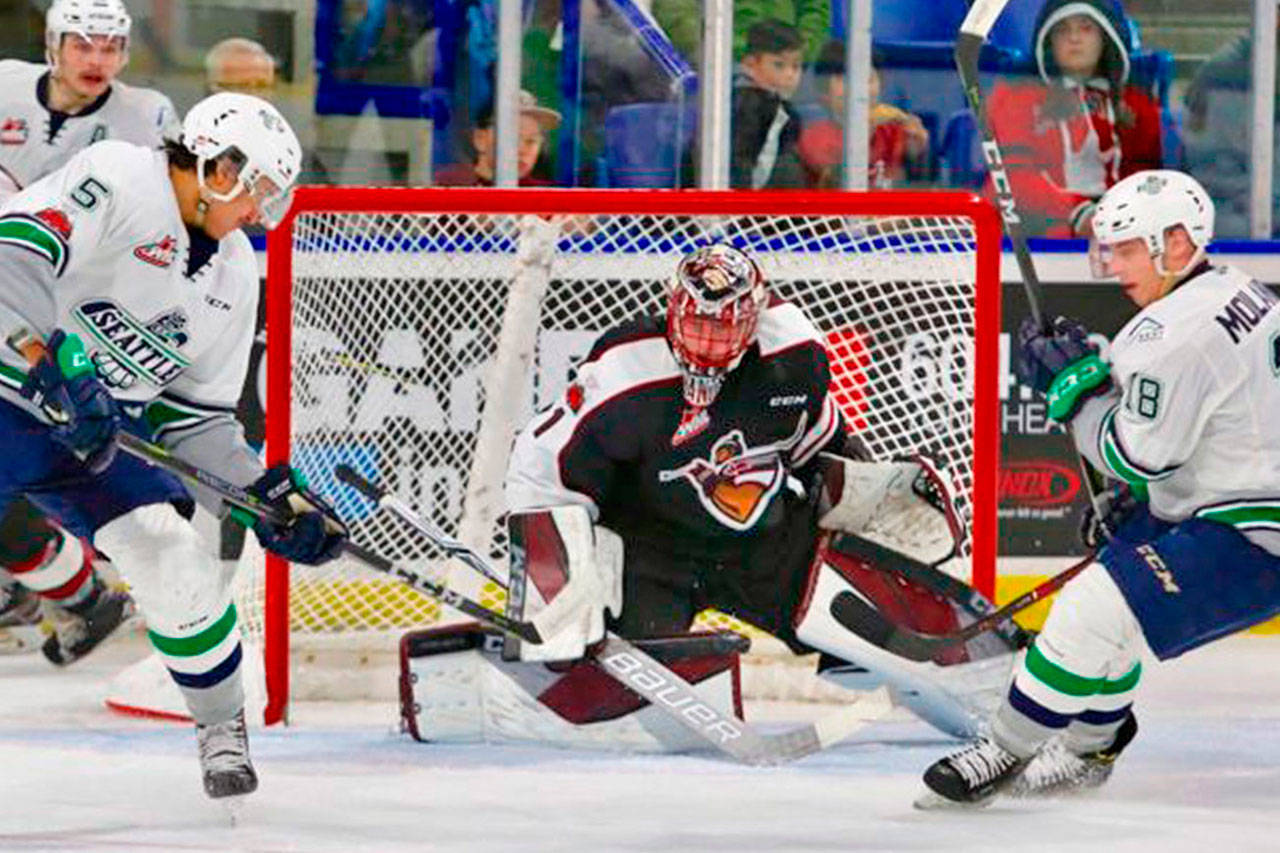 The Thunderbirds’ Jarret Tyszka, left, fires a shot at Giants goalie Todd Scott during WHL play Tuesday night. COURTESY PHOTO, Richard Fedyck