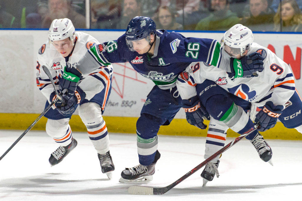 The Thunderbirds’ Nolan Volcan battles the Blazers’ Connor Zary, left, and Jackson Shepard for position during WHL play Saturday night. COURTESY PHOTO, Brian Liesse/T-Birds