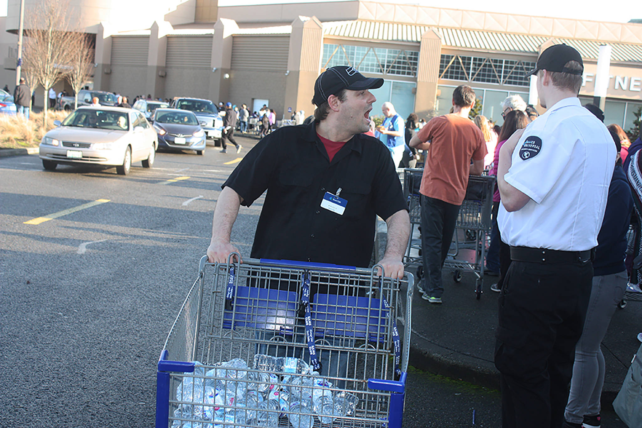 A Sam’s Club employee shouts to offer water to customers waiting patiently to get into the store on Saturday afternoon. The line stretched along one side of The Outlet Collection mall in Auburn, with patrons waiting an hour to an hour and a half to enter the bargain-selling store, which is scheduled to close Jan. 26. MARK KLAAS, Auburn Reporter
