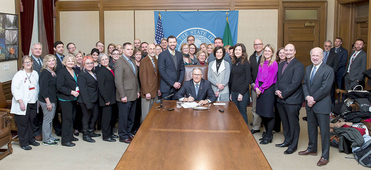 Legislation naming Washington state’s cancer research fund after the late Sen. Andy Hill was signed into law by Gov. Jay Inslee in Olympia. Hill’s wife, Molly, joined Sen. Joe Fain, who sponsored the bill, along with Hill’s former colleagues, legislative staff, cancer-prevention advocates and others at the ceremony. COURTESY PHOTO