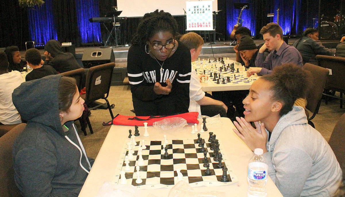 Phiona Mutesi, center, the Queen of Katwe as she is known, advises Samantha Valenzuela, left, a student at Kilo Middle School, and Tacoma Community College student Daniell Smith during a recent chess session at Family Life Community Church in Federal Way. Mutesi, the international chess champion featured in the movie, “Queen of Katwe,” was invited by members of the church who attend Northwest University in Kirkland with her. JESSICA KELLER, the Mirror