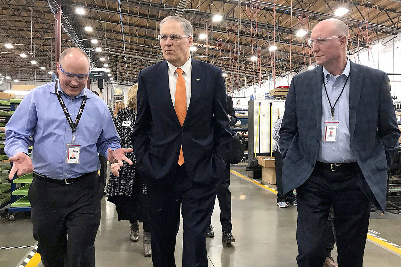 Tom Brosius, Orion vice president and general manager, left, and John Theisen, Orion president and CEO, far right, join Gov. Jay Inslee for a tour of the Auburn facility on Wednesday. COURTESY PHOTO, Layne Norris