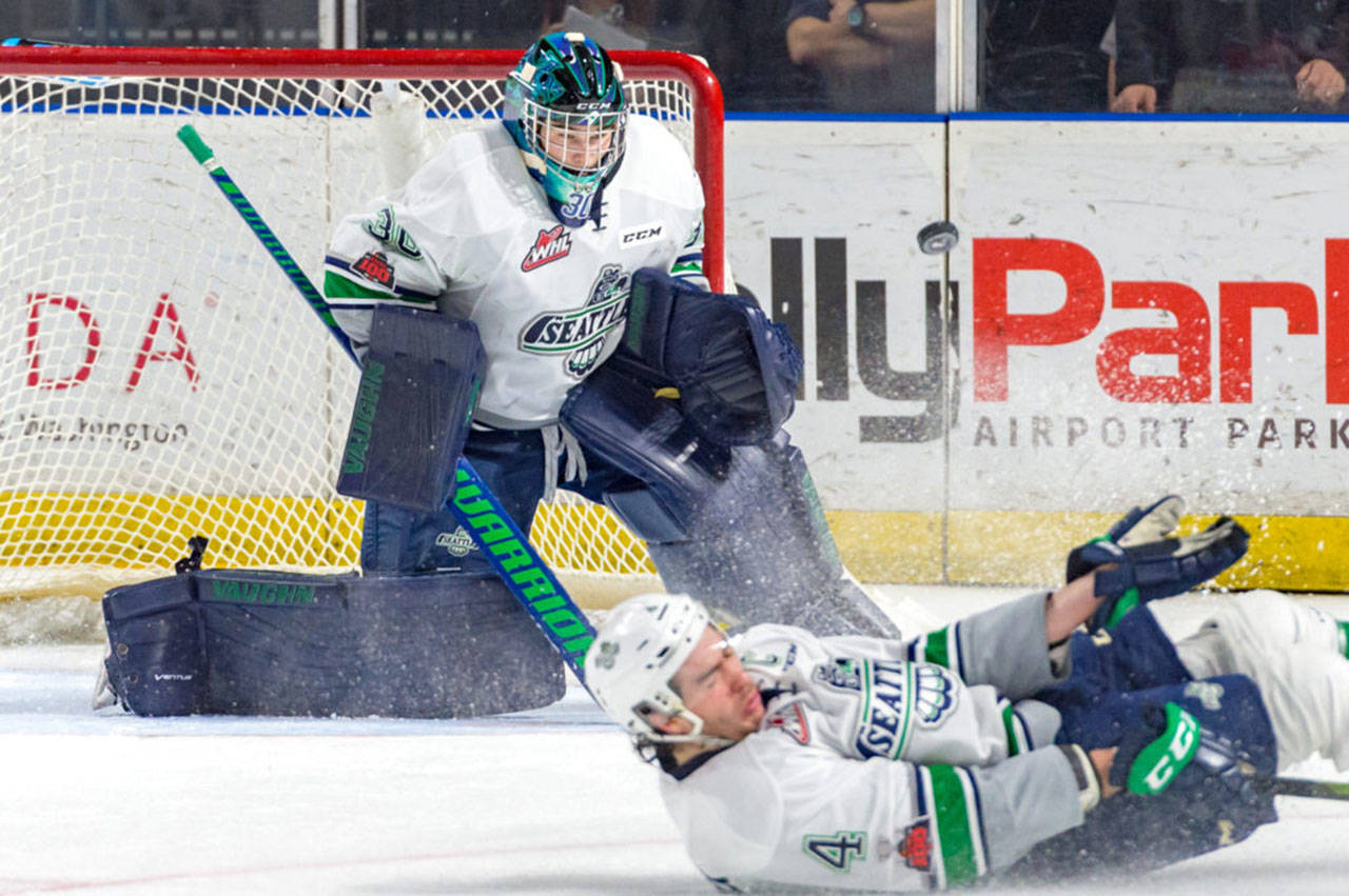 Thunderbirds defenseman Turner Ottenbreit slides to deflect the puck in front of goalie Liam Hughes during WHL play Tuesday night. COURTESY PHOTO, Brian Liesse, T-Birds