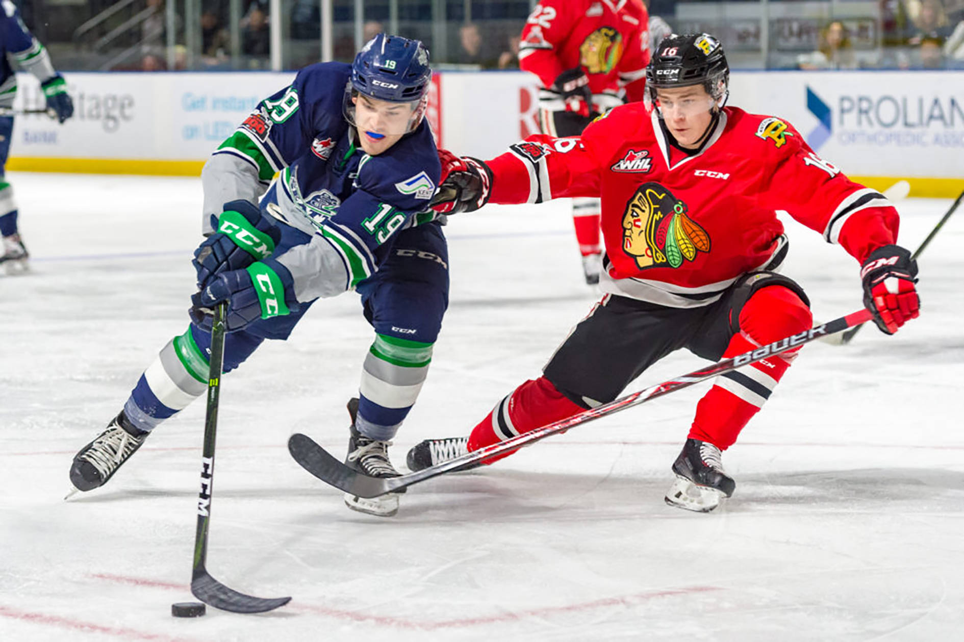 Thunderbirds center Donovan Neuls gathers the puck as the Winterhawks’ Henri Jokiharju defends during WHL play at the accesso ShoWare Center on Saturday night. COURTESY PHOTO, Brian Liesse, T-Birds