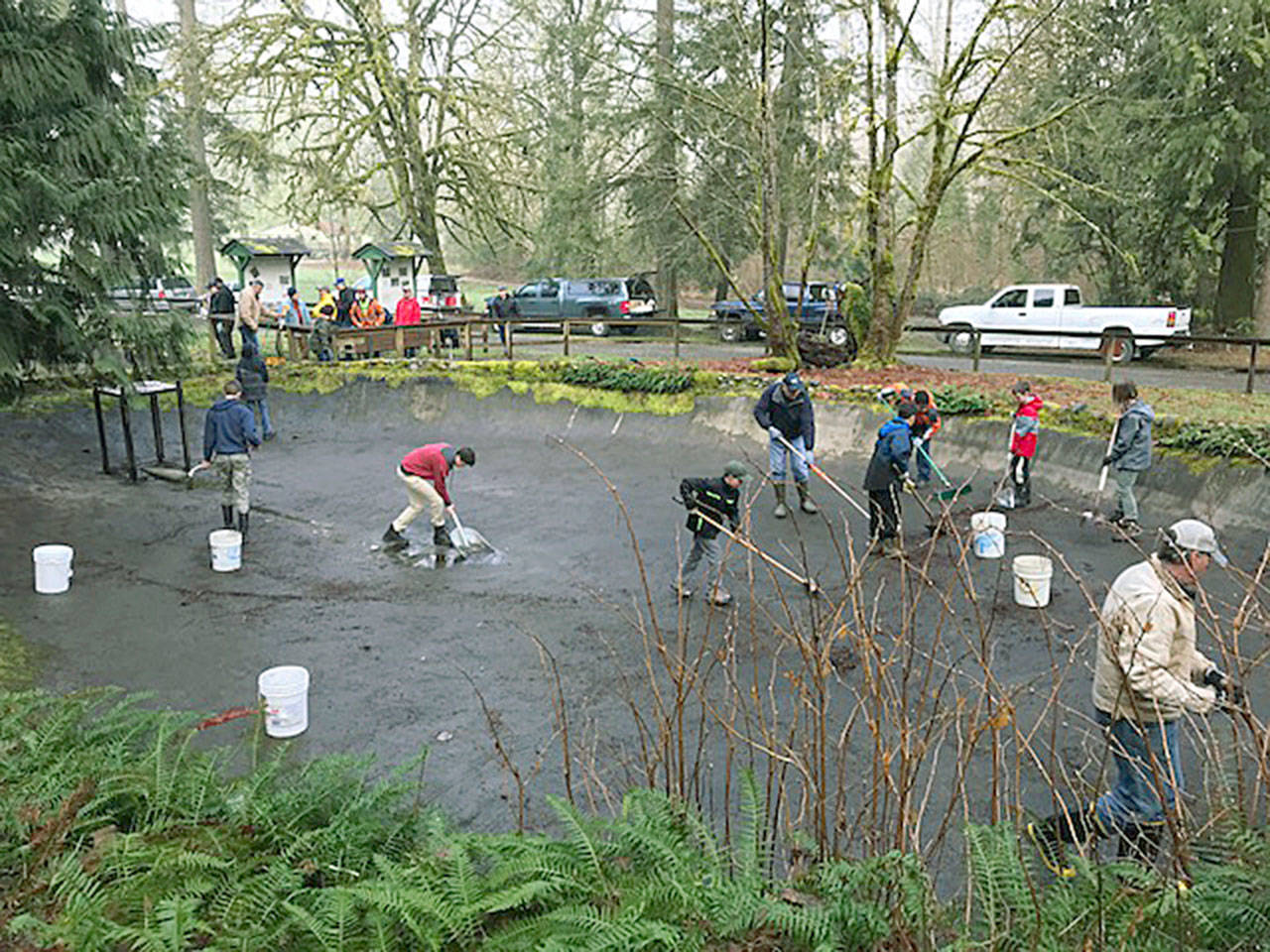 Volunteers prepare large concrete basins at Flaming Geyser State Park for the temporary holding and feeding of some 15,000 juvenile steelhead trout. COURTESY PHOTO