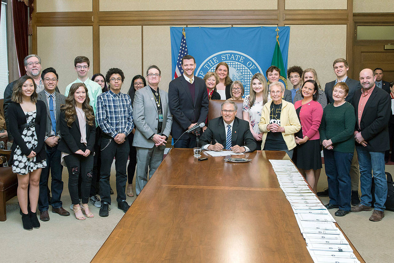 Student journalists, teachers, school administrators and advocates gathered in Olympia as Gov. Jay Inslee, middle, signed a law sponsored by Sen. Joe Fain, R-Auburn (to Inslee’s right), extending free speech protections to students publishing in high school and college newspapers. COURTESY PHOTO, Washington State Legislature