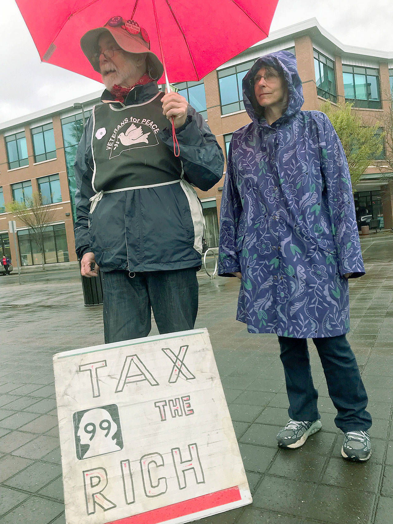 Dave Dittemore and Jo Scozzafava join other community members last Saturday on the Auburn City Hall Plaza to protest what they describe as a Congressional Republicans’ “tax giveaway” to the rich. MARK KLAAS, Auburn Reporter