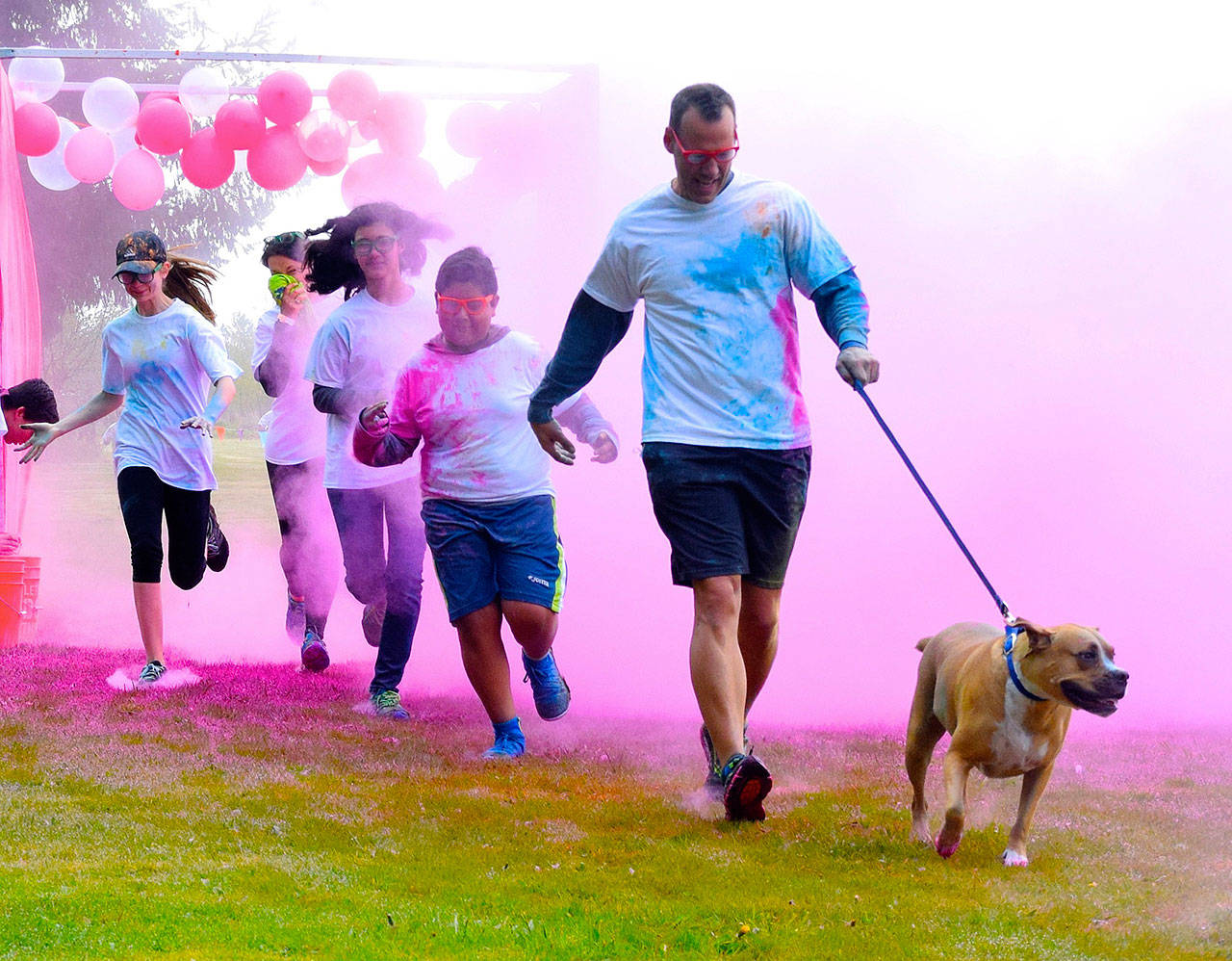 Participants charge through a color-throwing station during the Run2Educate Color Run at Buena Vista Seventh-day Adventist School on Sunday. RACHEL CIAMPI, Auburn Reporter