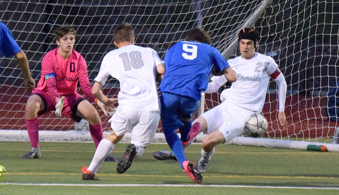 Auburn Riverside’s Reis McNeill, right, and Curtis Van Daele converge on Federal Way’s Connor Wells as goalkeeper Riley Dunne anticipates the shot during last Friday’s match. RACHEL CIAMPI, Auburn Reporter
