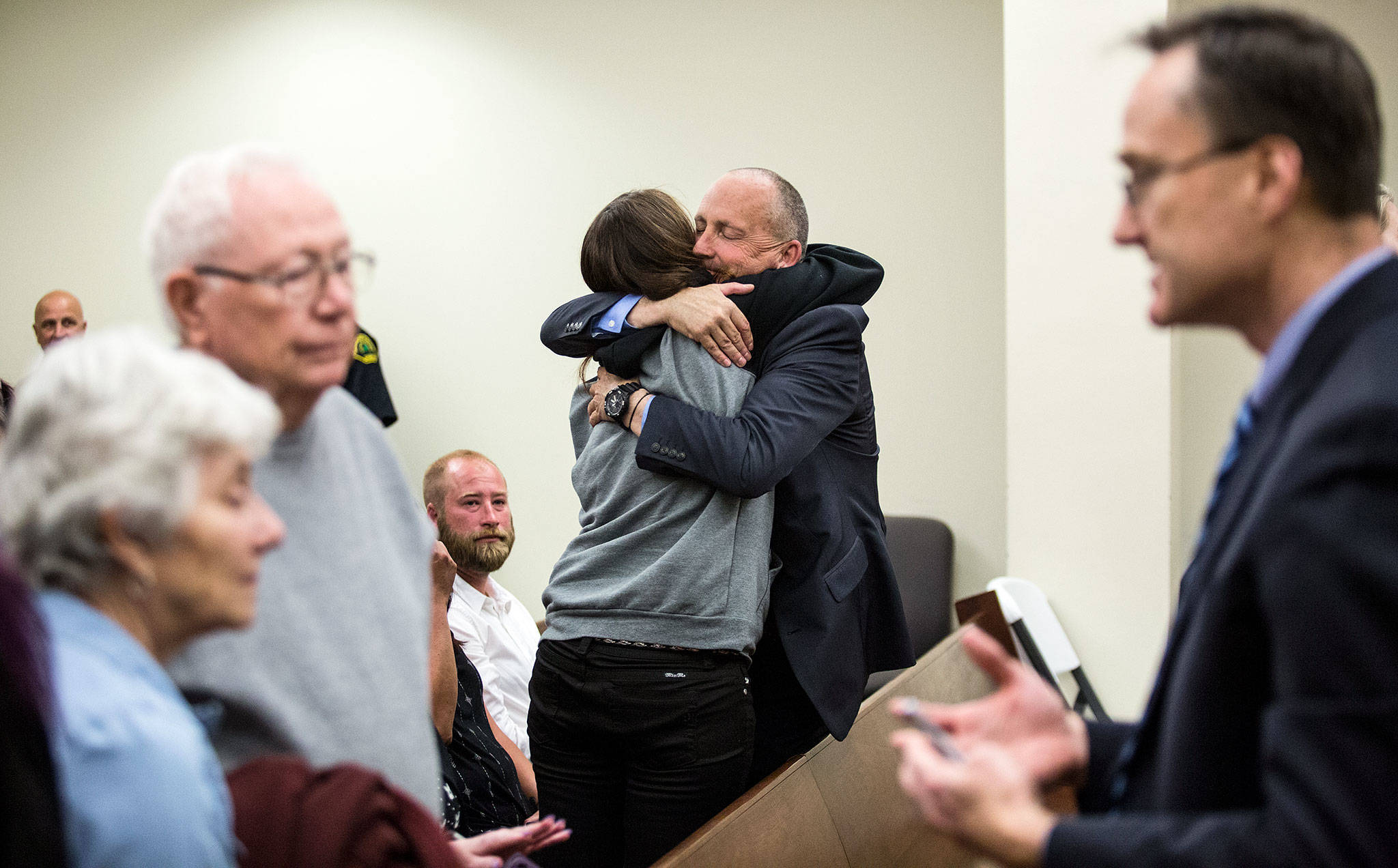 Snohomish County detective Dave Fontenot (center) is hugged as friends and family of Monique Patenaude and Patrick Shunn react to the guilty verdict for John Reed at the Snohomish County Courthouse on Wednesday in Everett. At right,Snohomish County chief criminal deputy prosecutor Craig Matheson talks with Shunn’s parents (left). (Andy Bronson / The Herald)