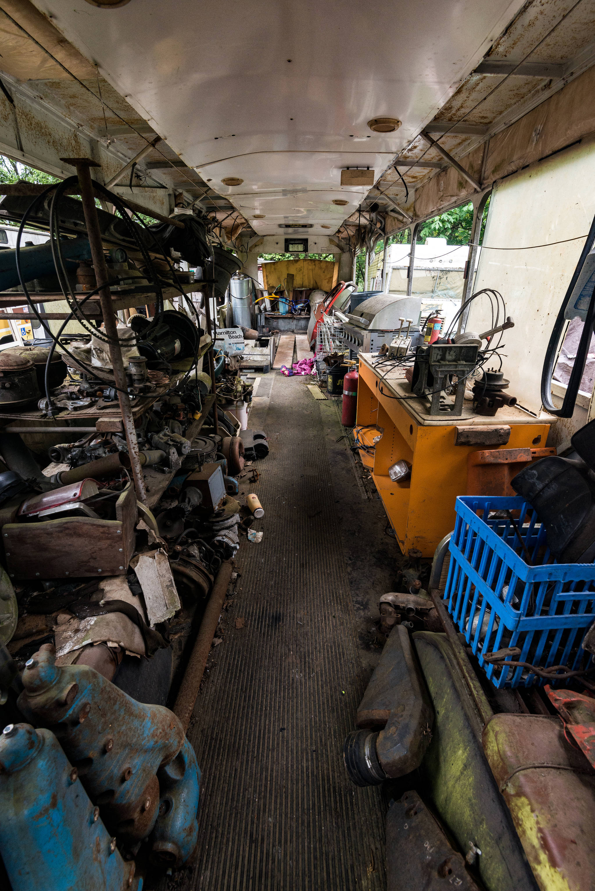 The interior of one of the several buses found on Pillon’s property. The buses in the illegal junkyard are often used as storage for other artifacts found in the rubble. Photo by Caean Couto