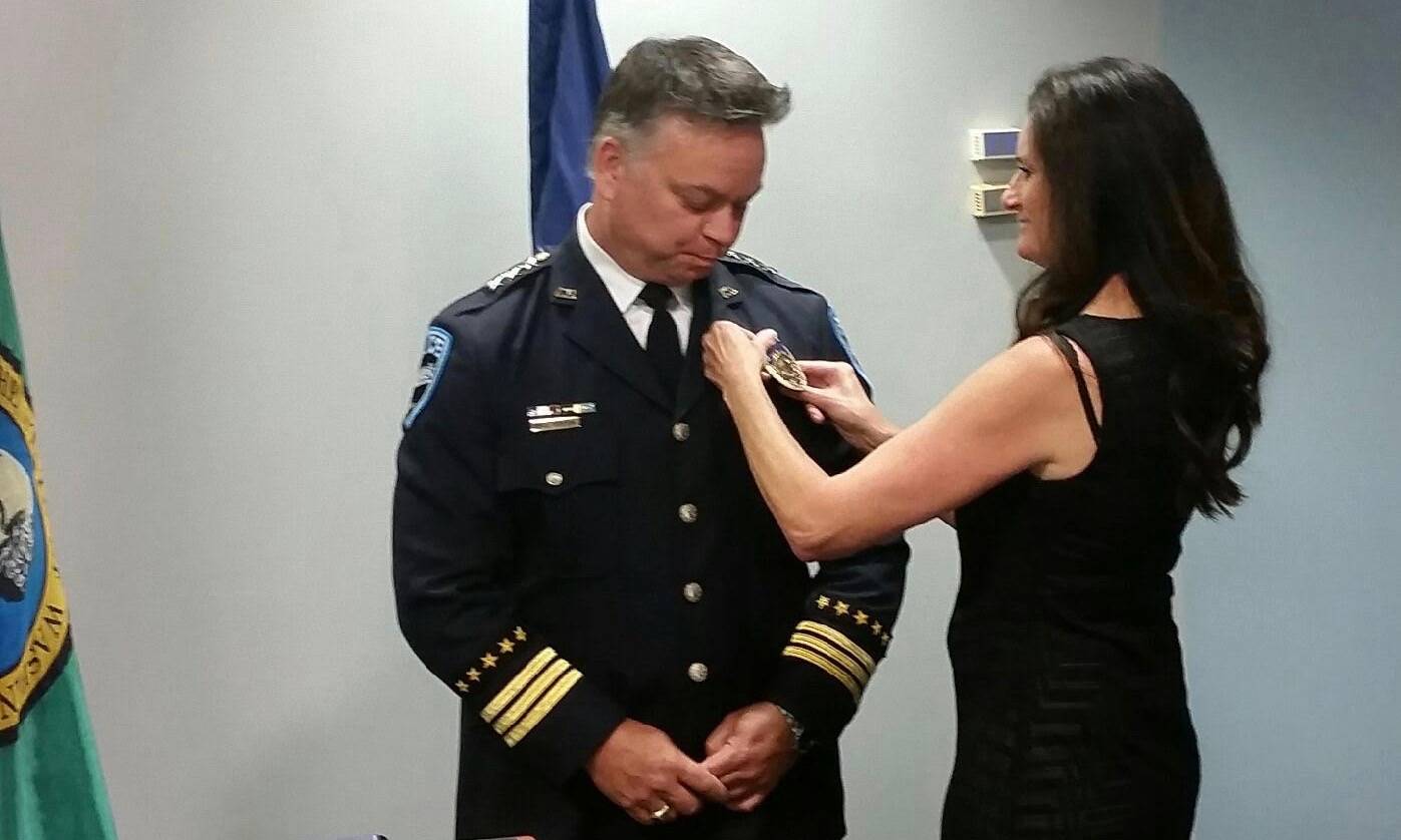 Debbie Pierson pins the badge on her husband, William Pierson, shortly after he took the oath of office to become the City of Auburn’s new Police Chief, Monday night at Auburn City Hall. ROBERT WHALE, Auburn Reporter