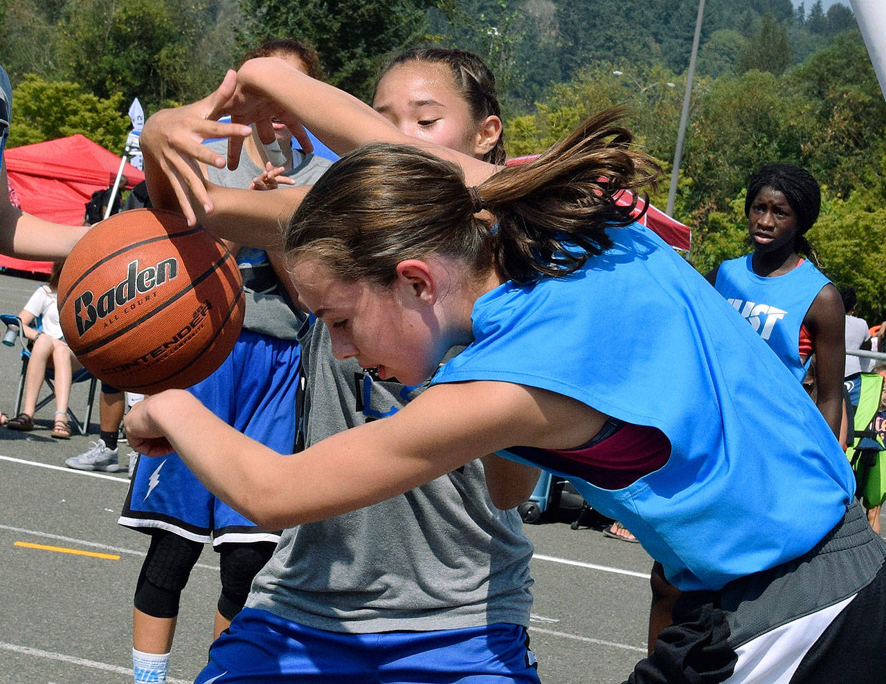 The Just Do It light blue team tangles the LSN gray team for the ball during seventh-grade division play at the Slick Watts Classic 3-on-3 outdoor basketball tournament last Saturday. RACHEL CIAMPI, Auburn Reporter