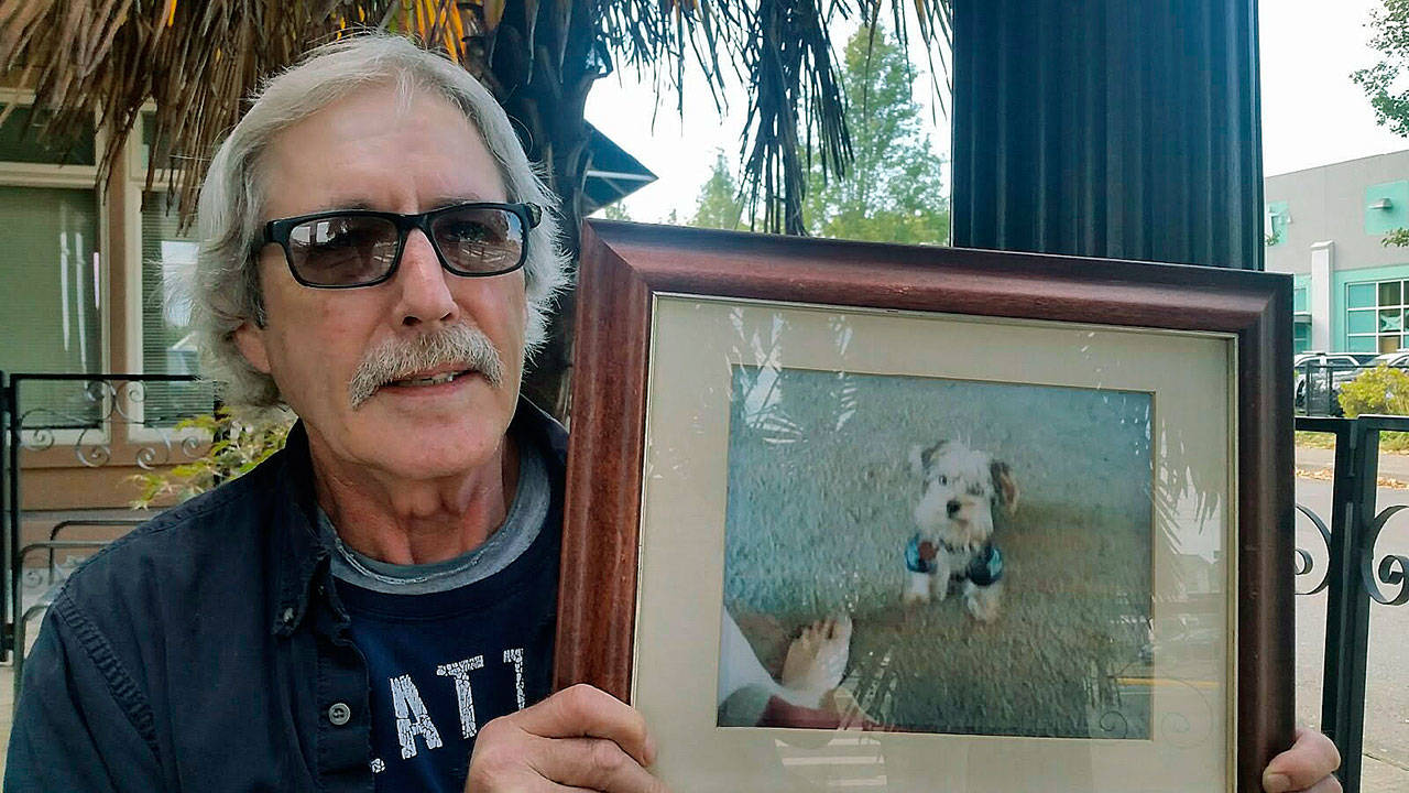 Charles Howley with a photo of Rosco in happier times. ROBERT WHALE, Auburn Reporter